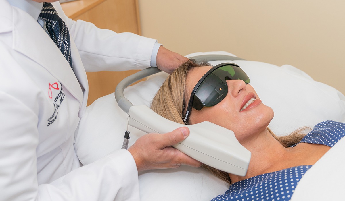 Dr. Vu Using Photofacial Device on Female Patient's Face While She Wears Protective Eyewear